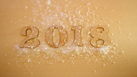 Top view. Falling snow on figures 2018 lying on a wooden table. Stock Footage 82951841