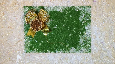 Top view of falling snow on the green background whith bump and golden bow. Stock-Footage 83003223