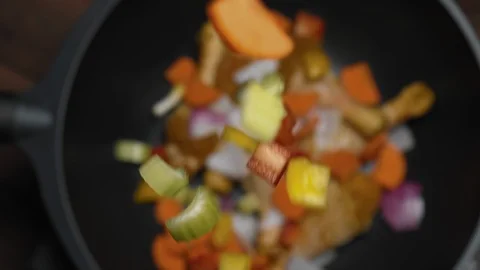 Top view of falling vegetables in hot skillet or wok in the kitchen or diner Stock Footage 123571457