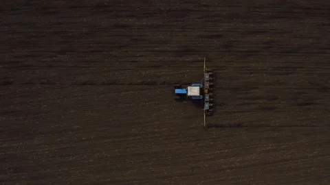 Top view of farm machine plowing the black earth drone footage Stock Footage 114600923