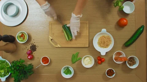 Top view of female hand cut Cucumber, tomato, fish, oregano, sauce, cheese Stock Footage