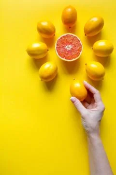 Top view female hand, whole and sliced ripe lemons, grapefruit laid out in th Stock Photos