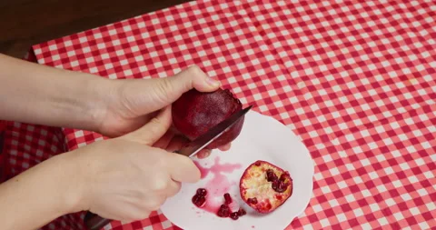 Top view of female hands making incision on pomegranate with knife Stock Footage 234223365