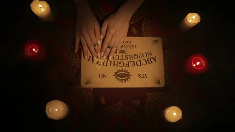 Top view of a female hands moving over the spirit ouija board game, reading the Stock-Footage 247982674