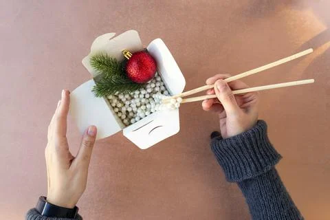 Top view of female hands pull out white beads from a food box with Chinese ch Stock Photos