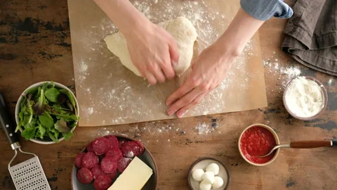 Top view, female hands put dough, prepare Italian pizza with sauce, tomatoes Stock Footage 142760253