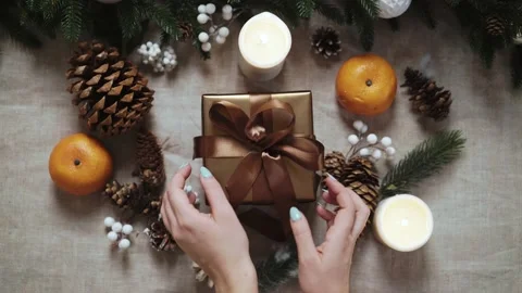 Top view of female hands put New year present on table with New year decoration 库存影片 143811319