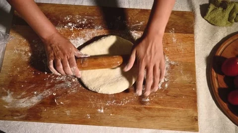 Top view of female hands rolling pizza dough using rolling pin. Woman doing home Stock Footage 156410583