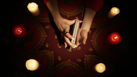 Top view, female hands shuffling tarot cards, surrounded by many candles on the Stock Footage 247978163