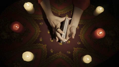 Top view, female hands shuffling tarot cards, surrounded by many candles on the Stock Footage 248002843