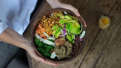 Top view of female hands table setting, holding tasty healthy vegan bowl with Stock Footage 170592326