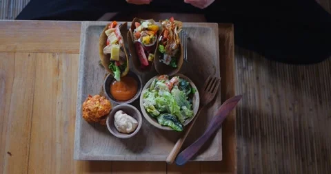 Top view of female hands taking taco in cozy vegan restaurant or cafe setting Stock Footage 282971981