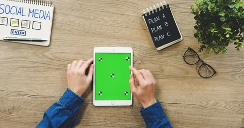 Top view on the female hands taping on the white tablet device with a green Stock Footage 89980934