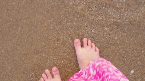 Top view of female legs, which washed by waves of sea. A woman in dress standing Stock Footage 220187389