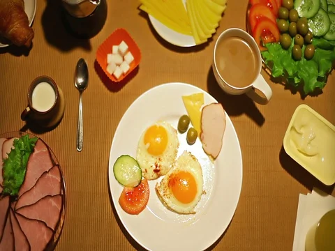 Top view female taking a bite of fried eggs for breakfast Stock Footage 73257574
