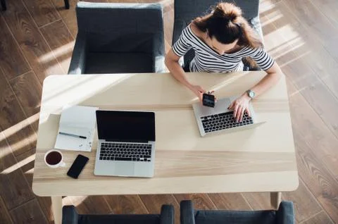 Top view of female using her laptop at a cafe. Overhead shot of young woman Stock Photos