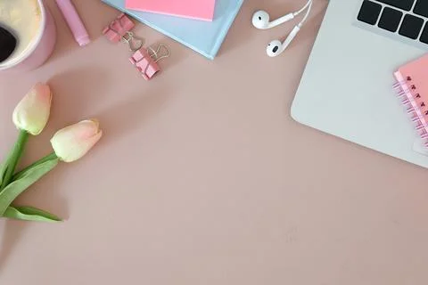 Top view, female workspace with computer laptop, notebook and pink tulips. Stock Photos