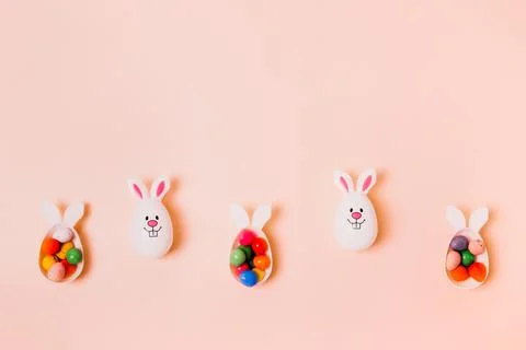 Top view festive Easter beige peach color background with funny bunny eggs Stock Photos