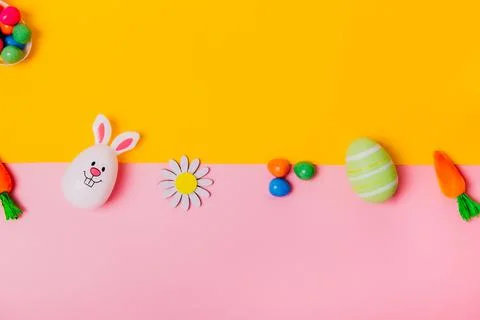 Top view festive Easter pink and yellow background with colored eggs, decorative Stock Photos