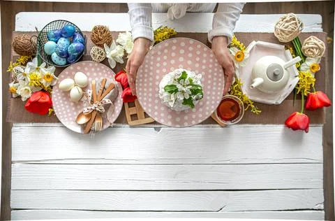 Top view festive Easter table with homemade Easter cake, flowers and tea. Stock Photos