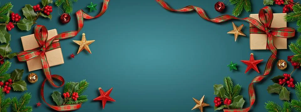 Top view festive frame with wrapped gifts, ornaments, and greenery on a blu.. Stock Photos