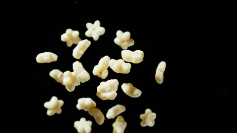 TOP VIEW: Figural corn flakes fly up and down on a black background, Slow motion Vídeo Stock 149543381