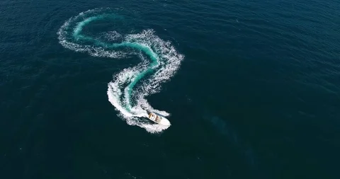 Top view figure of dollar made with foamy speedboat traces on azure ocean Video stock 91667123