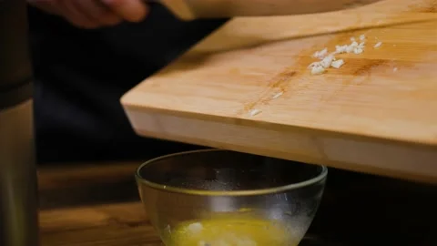 Top view. Finely chopped garlic is poured into a transparent plate Video stock 188540683