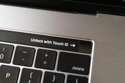 Top view of a fingerprint sensor on touch bar of MacBook Pro with sign Unlock Stock Photos