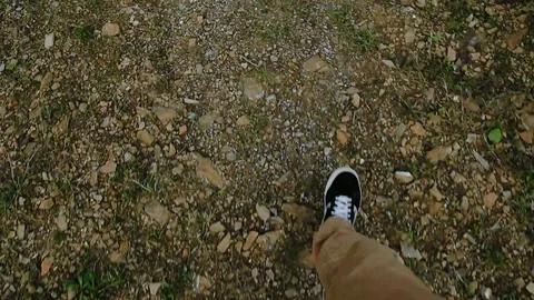 Top view, first person view of male in stylish sneakers walking down the gravel 스톡 동영상 105271652