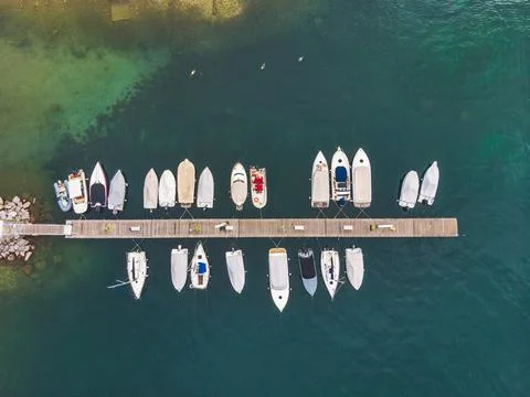A top view of fishing boats anchoring in marina next to jetty wooden pier Stock Photos