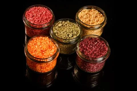 Top view of five glass jars filled with different colors sea salt 写真素材