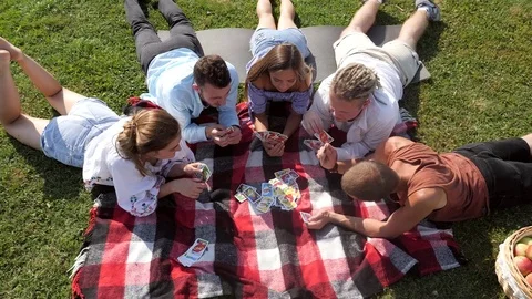 Top view of five people playing card game on the grasse. Stock Footage