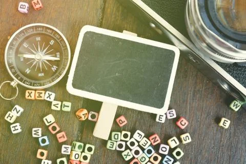 Top view flat lay blank signage,compass and vintage camera on wooden table wi Stock Photos