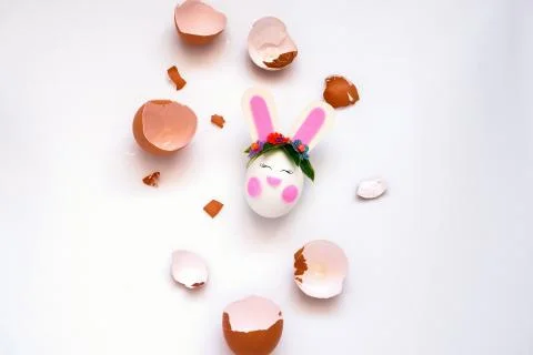 Top view flat lay brown eggs shell and cute bunny Easter egg on a white backg Stock Photos