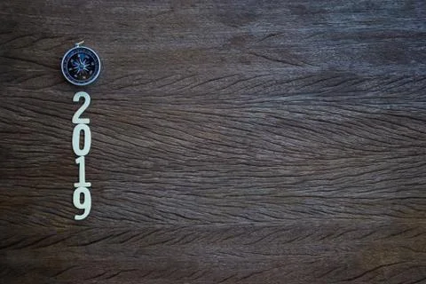 Top view, flat lay compass and a cut wood number 2019 on wood table Stock Photos