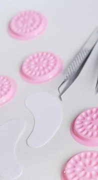 Top view flat lay featuring silver professional lash tweezers, white hydrogel Stock Photos