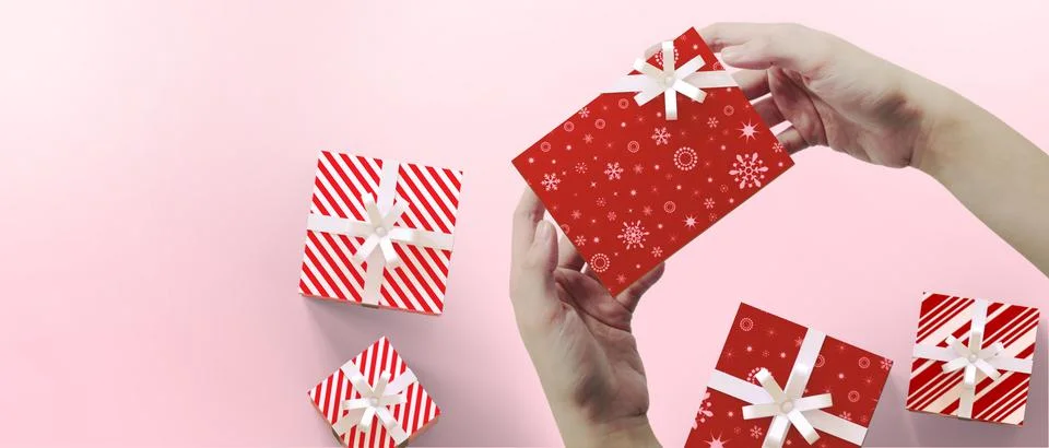 Top view, flat lay. Gift Box and hands holding present box or package on pink Stock Illustration