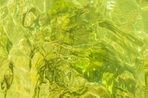 Top view flat lay of golden lime green water surface with rippled texture p.. Foto stock