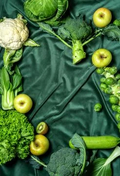 Top view of flat lay green vegetables frame on a green velvet curtain, copy.. Stock Photos