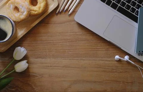 Top view flat lay laptop computer, coffee cup, glasses and donuts on wooden t Stock Photos