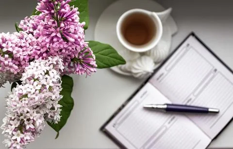 Top view flat lay with lilac flowers in a white vase on a windowsill. Notepad Stock Photos