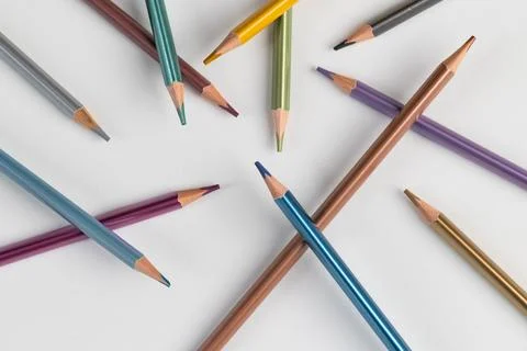 Top view flat lay of multicolored metallic pencils scattered on white backg.. Stock Photos