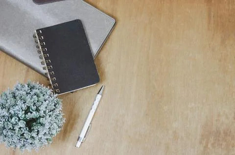 Top view flat lay notebook and flower and pen on wood table.Copy space Stock Photos