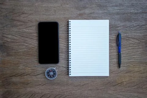 Top view, flat lay office supply note book, pen and compass and smartphone wi Stock Photos