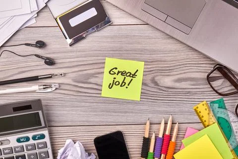 Top view flat lay office stuff and sticky note with great job writing. Stock Photos