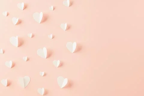 Top view flat lay of paper elements cutting white hearts shape flying on pink 库存照片