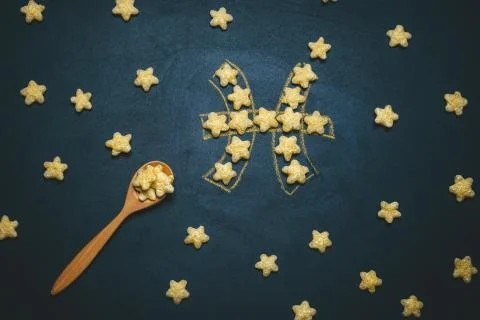 Top view flat lay Pisces, horoscope sign made from crispy corn stars on a bla Stock Photos