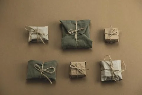 Top view flat lay textile and kraft paper gift boxes on a brown background Stock Photos