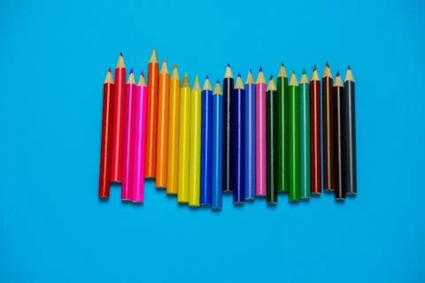 Top view flat lay vibrant wooden multicolored pencils on a blue background Stock Photos